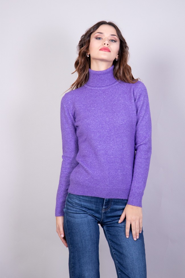 Una donna con un maglione viola a collo alto